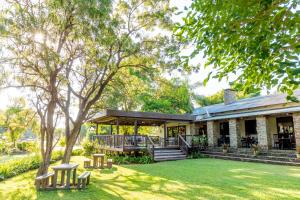 a house with a porch and a yard at Hamiltons Lodge & Restaurant in Malelane