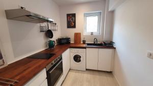 a kitchen with white cabinets and a washer and dryer at I&K's apartment in Sofia