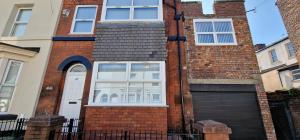 a brick house with a door and a garage at LFC Anfield Guest House in Liverpool