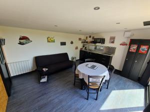 ein Wohnzimmer mit einem Tisch und einem Sofa in der Unterkunft Au Saule en Seine in Saint-Wandrille-Rançon