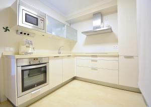 a kitchen with white cabinets and a microwave at GALIHOST - Apartamento frente al mar en Cambados in Cambados +13 photos