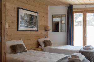 a bedroom with two beds and a mirror at Chalet Makalu in Les Gets