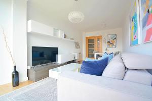 a living room with a white couch and a tv at Apartamento frente al mar en Cambados in Cambados