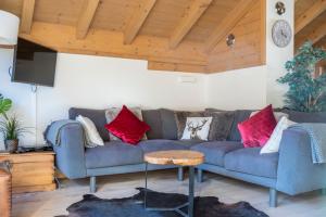 萊熱的住宿－Chalet Makalu，客厅配有蓝色沙发和红色枕头