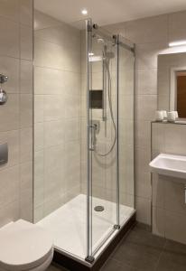a bathroom with a shower with a toilet and a sink at Filder-Appartements in Filderstadt