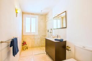 a bathroom with a sink and a mirror at Casa Pura - Luxuriöses Ferienhaus mit Meerblick in Llucmajor