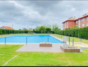 a large swimming pool in a park with a building at Coto Carcedo in Salinas