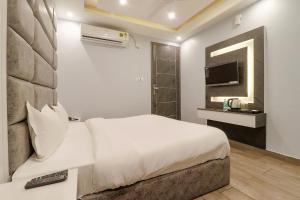 a hotel room with a bed and a television at FabHotel Av Royale in Dehradun