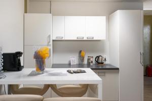 a kitchen with white cabinets and a table with chairs at Cannstatter Hotel in Stuttgart