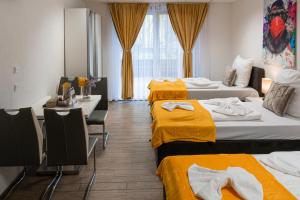 a hotel room with three beds with yellow sheets at Cannstatter Hotel in Stuttgart