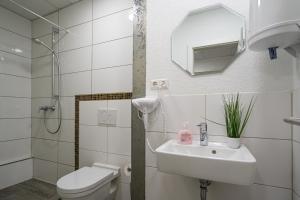 a white bathroom with a sink and a toilet at Cannstatter Hotel in Stuttgart