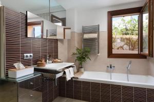 Un baño con bañera, lavabo y espejo. en Can Vicens -Mancor-, en Mancor del Valle