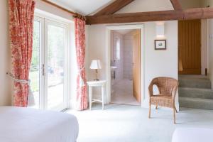 a bedroom with a bed and a chair and a bathroom at Chater Barn in Leicester