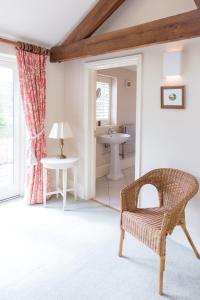 a bathroom with a rattan chair and a sink at Chater Barn in Leicester