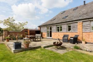 a garden with a patio and a house at Chater Barn in Leicester