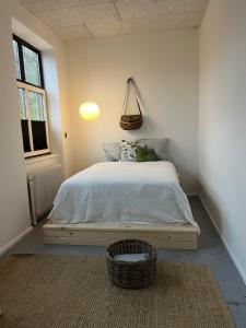 a bedroom with a bed with a basket on it at Room 6 - Hawkraft Kulturhotel in Vestervig