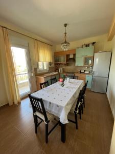 a kitchen with a table with chairs and a refrigerator at Villa Palma in Skala Rachoniou