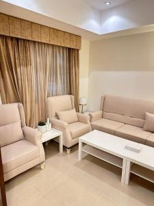 a living room with two couches and a coffee table at شاليهات ويف -Wave Resort in Al Khobar