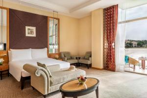 a hotel room with a bed and a couch and a table at Al Raha Beach Hotel in Abu Dhabi