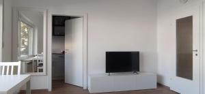 a living room with a tv on a white wall at Frisch renoviertes Appartement in Mönchengladbach
