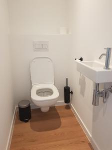 ein Badezimmer mit einem weißen WC und einem Waschbecken in der Unterkunft The One - New luxury beachfront apartment in Blankenberge