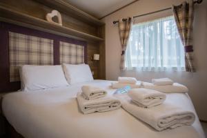 コルチェスターにあるMersea Island by Away Resortsのベッドルーム1室(白いベッド1台、タオル付)