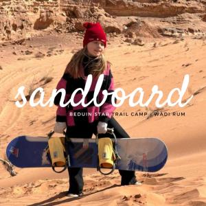 a young girl holding a snowboard in the desert at Beduin Star Trail Camp in Wadi Rum