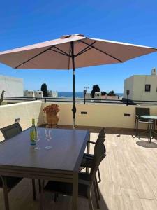 - une table avec un parasol et deux verres à vin dans l'établissement Casa Linda, à Albufeira
