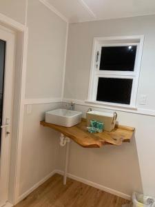 a bathroom with a sink and a window at Cute and Cozy near Airport in Auckland