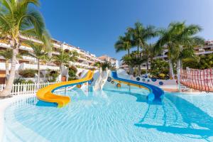 a water slide at a resort with palm trees at Parque Santiago III Official in Playa de las Americas