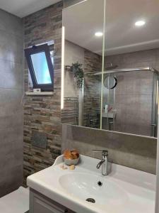 La salle de bains est pourvue d'un lavabo et d'une télévision murale. dans l'établissement Casa Linda, à Albufeira