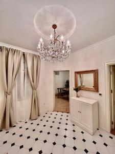 a living room with a chandelier and a tiled floor at Pop luxury apartments in Belgrade