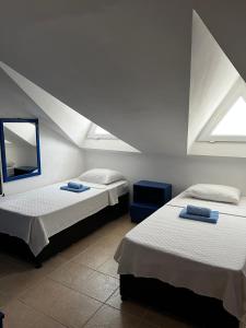 two beds in a room with two windows at New Golden Gate Butik Otel in Muğla