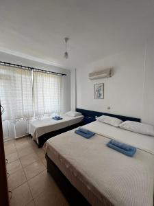 a bedroom with two beds and a window at New Golden Gate Butik Otel in Muğla