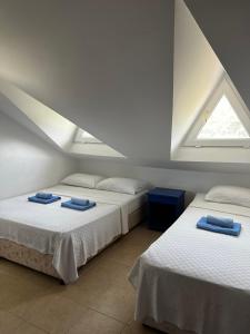 two beds in a room with two windows at New Golden Gate Butik Otel in Muğla