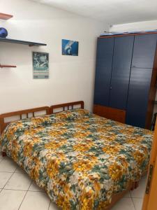 a bedroom with a bed with a floral bedspread at La casa sul ponte in Castelgrande
