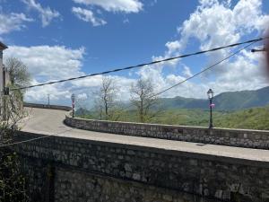 a mountain road with a stone wall and a street light at La casa sul ponte in Castelgrande