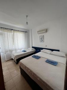 a bedroom with two beds and a window at New Golden Gate Butik Otel in Muğla