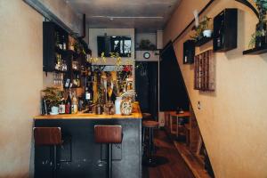 a bar in a pub with a counter and stools at Backstage Party Hostel & Bar in Osaka