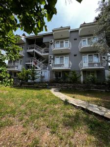 an apartment building with balconies and a yard at New Golden Gate Butik Otel in Muğla