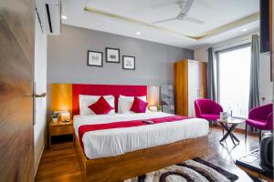 1 dormitorio con 1 cama grande y cabecero rojo en Saltstayz Hotel Huda City Center, en Gurgaon