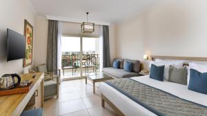um quarto de hotel com uma cama e uma sala de estar em Iberotel Casa Del Mar Resort em Hurghada