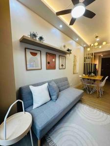 sala de estar con sofá azul y mesa en Condotel Vibe at Spring Residences near Airport, en Manila