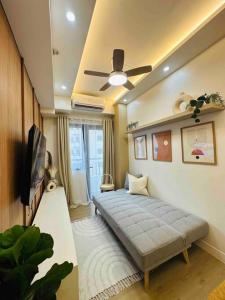 1 dormitorio con 1 cama y ventilador de techo en Condotel Vibe at Spring Residences near Airport, en Manila
