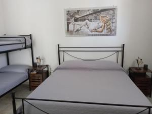 - une chambre avec 2 lits et une photo sur le mur dans l'établissement B&B Lo Scrigno del Salento, à Sava