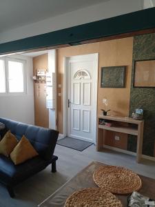 sala de estar con sofá azul y puerta en Appart nuitée (24h du Mans) en Noyen-sur-Sarthe
