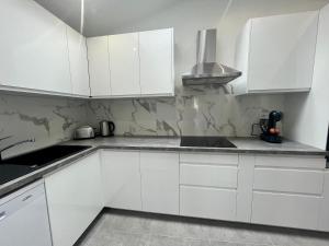 利摩日的住宿－Maison moderne climatisée - DABNB，白色的厨房配有白色橱柜和水槽