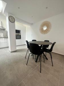 comedor con mesa, sillas y reloj en Maison moderne climatisée - DABNB, en Limoges