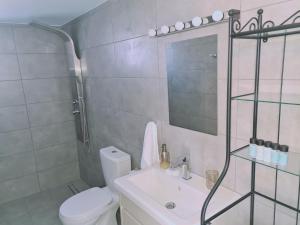 a white bathroom with a toilet and a sink at STAY BelleVue Apartment in Khlorakas +49 photos
