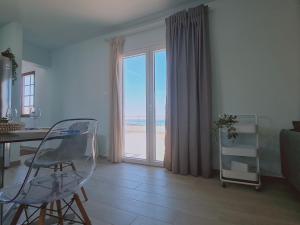a living room with a desk and a view of the beach at STAY BelleVue Apartment in Khlorakas